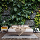 Tropical leaf wallpaper in modern living room showing lush green foliage against textured stone wall