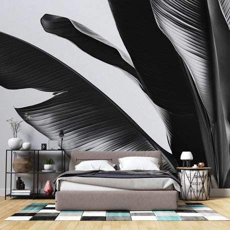 Black and white tropical leaf wallpaper creating a stunning focal point in a modern minimalist living room with natural light