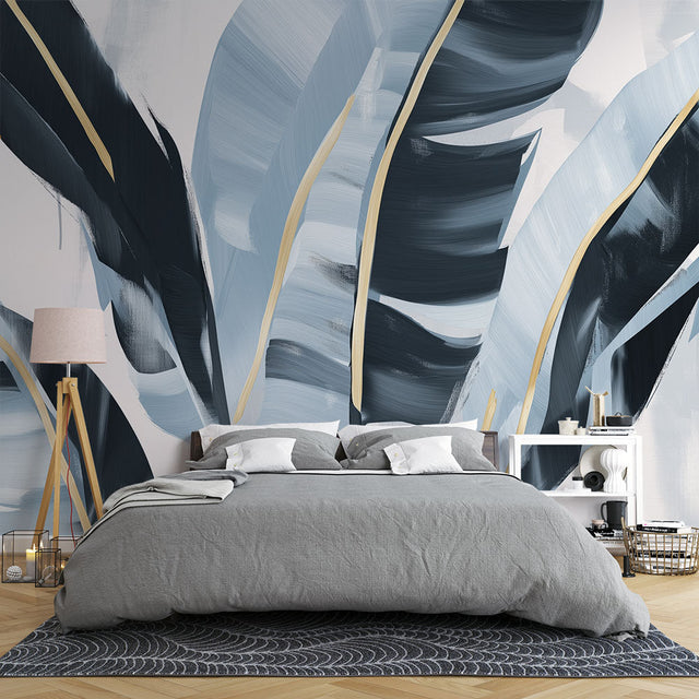 Tropical leaf wallpaper with gold accents creating a luxury feel in a modern living room with natural light