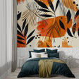 Tropical leaf wallpaper bringing warmth to a modern living room with black and orange pattern