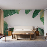 Tropical banana leaf wallpaper creating a fresh accent wall in a bright living room with modern furniture