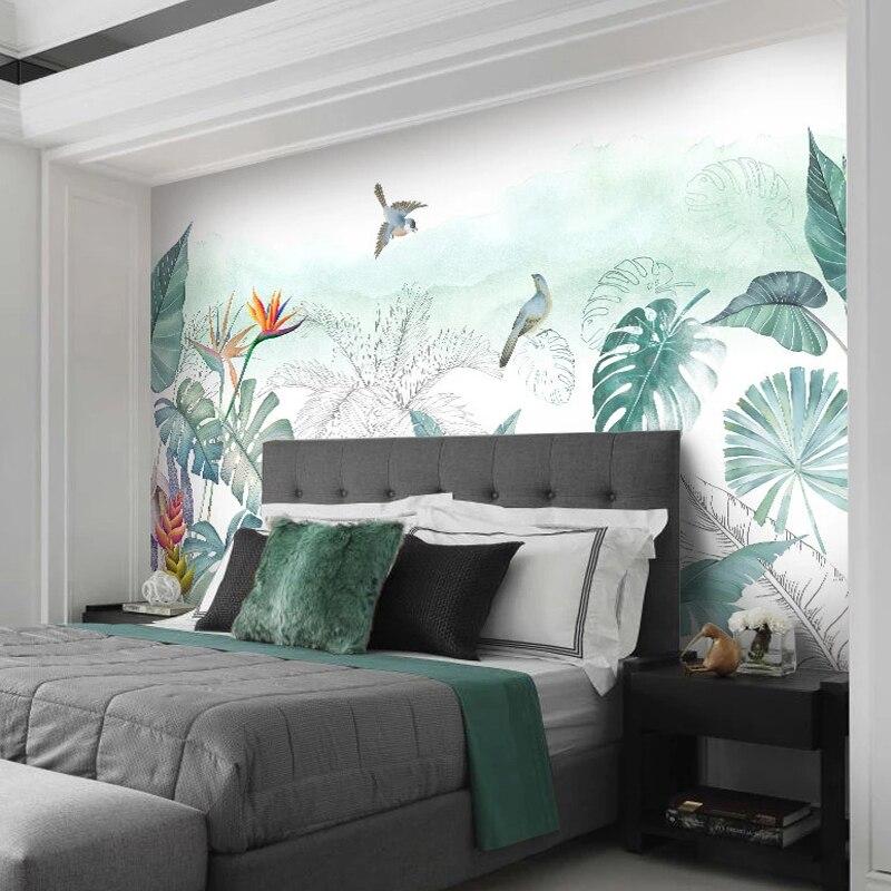Bedroom wall featuring exotic birds and monstera leaves mural in soft morning light