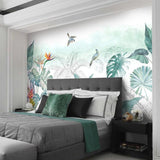 Bedroom wall featuring exotic birds and monstera leaves mural in soft morning light
