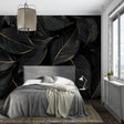 Black and gold leaf wallpaper in modern dining room with pendant lights highlighting metallic details