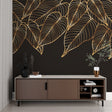 Tropical black and gold leaf wallpaper in modern living room with grey sofa and natural light
