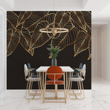 Black and gold palm leaf mural in dining room with pendant lighting