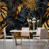 Black and gold leaf pattern mural in stylish dining room with pendant lights