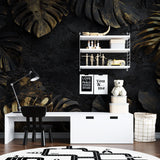 Monstera leaf wallpaper adding drama to hallway with modern furniture
