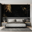 Black and gold tropical wallpaper creating drama in modern living room with grey sofa