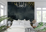 Tropical black and gold palm leaves wallpaper in modern living room with dark furniture