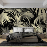 Black and gold tropical palm wallpaper creating drama in a modern dining room with ambient lighting