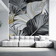 Tropical palm leaves wallpaper in black and gold creating drama in a modern living room with high ceilings