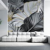 Tropical palm leaves wallpaper in black and gold creating drama in a modern living room with high ceilings