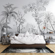 Black and white tropical wallpaper creating depth in modern living room with grey sofa