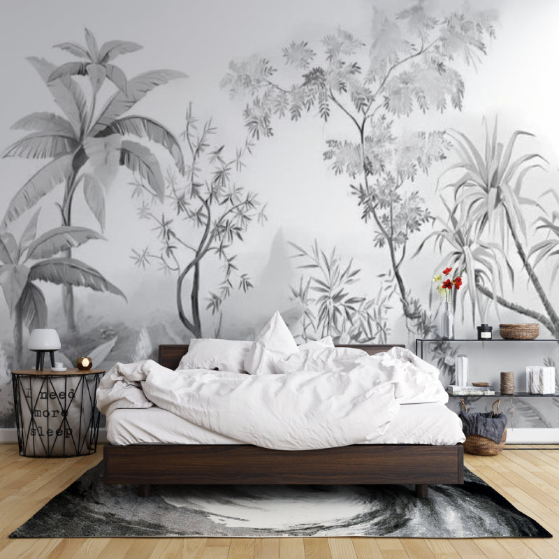 Black and white tropical wallpaper creating depth in modern living room with grey sofa