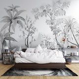Black and white tropical wallpaper creating depth in modern living room with grey sofa