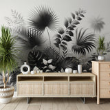 Black and white tropical botanical wallpaper creating drama in a modern living room with minimal furniture
