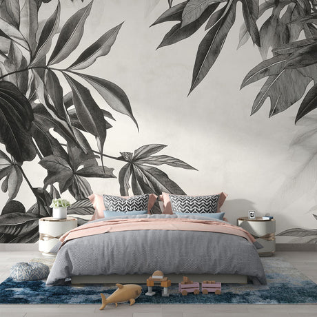 Black and white tropical leaf wallpaper creating drama in a modern living room with clean furniture and natural light