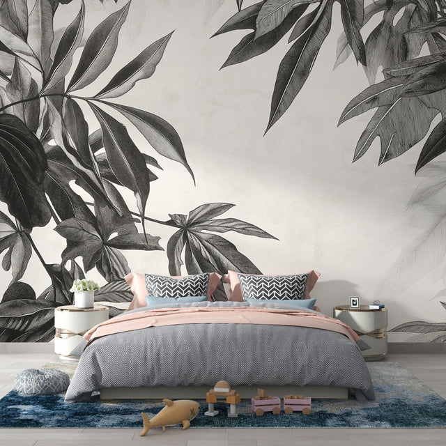 Black and white tropical leaf wallpaper creating drama in a modern living room with clean furniture and natural light