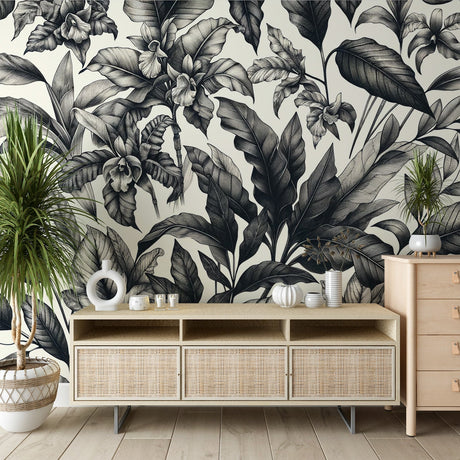 Black and white tropical leaf wallpaper creating a sophisticated atmosphere in a modern living room with minimal furniture