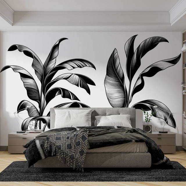 Black and white tropical leaf wallpaper creating a bold statement in a modern minimalist living room with white furniture