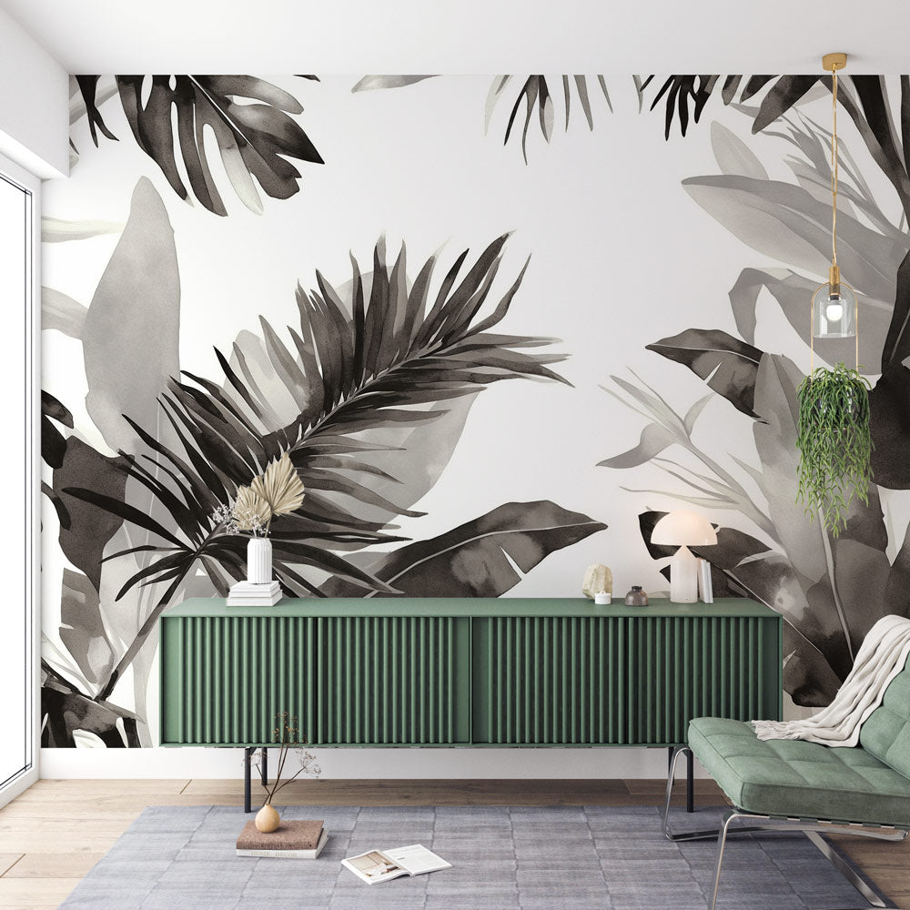 Black and white Monstera leaf wallpaper creating a dramatic statement wall in a modern living room with natural light