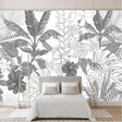 Black and white Monstera leaf wallpaper in a bright modern living room with minimal furniture and natural light