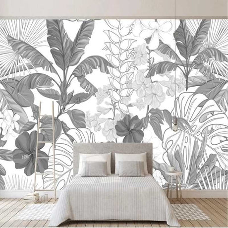 Black and white Monstera leaf wallpaper in a bright modern living room with minimal furniture and natural light