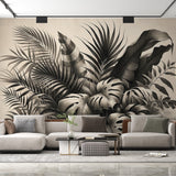Black and white tropical wallpaper with monstera leaves creating drama in a modern living room with minimal furniture