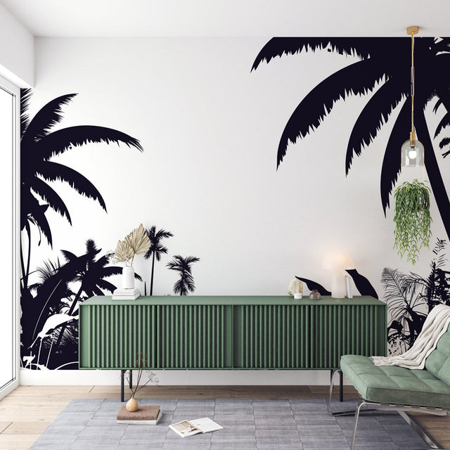 Black and white tropical palm wallpaper creating a dramatic feature wall in a modern living room with minimal furniture