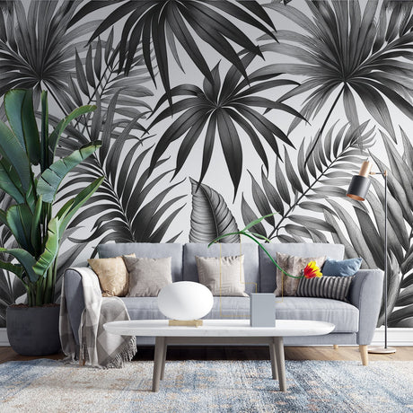 Black and white tropical palm leaf wallpaper creating dramatic contrast in a modern living room with minimalist furniture