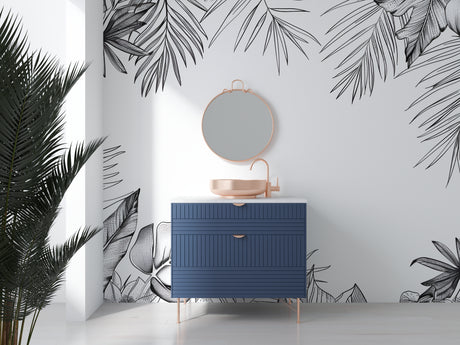Black and white tropical palm leaf wallpaper in a bright modern living room setting with minimal furniture