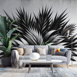 Black and white tropical palm leaf wallpaper creating a stunning focal point in a modern living room with minimal furniture