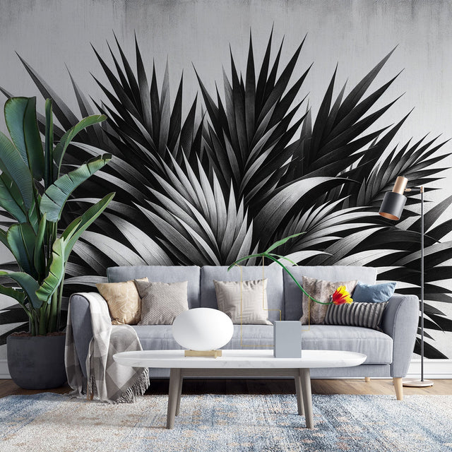 Black and white tropical palm leaf wallpaper creating a stunning focal point in a modern living room with minimal furniture