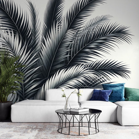 Black and white tropical palm leaf wallpaper creating drama in a modern minimalist living room with natural light