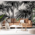 Black and white tropical palm leaf wallpaper creating dramatic impact in a modern living room with high ceilings