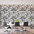 Black and white tropical palm leaf wallpaper creating a modern statement wall in a bright living room setting