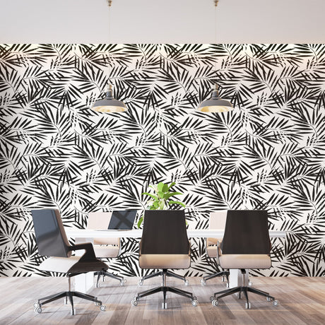 Black and white tropical palm leaf wallpaper creating a modern statement wall in a bright living room setting