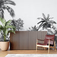 Black and white tropical palm mural creating drama in modern living room with grey sofa
