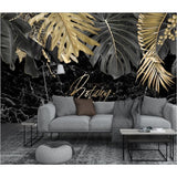 Tropical black and gold leaf wallpaper in modern living room showing dramatic marble effect and metallic accents