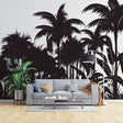 Tropical palm tree silhouette wallpaper creating drama in a modern living room with white sofa and minimal decor