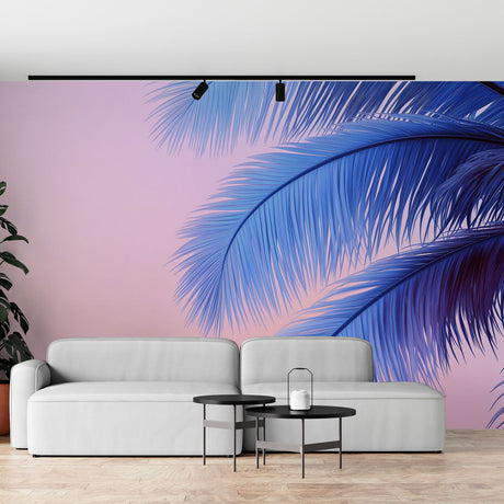 Tropical palm leaf wallpaper with blue fronds on pink background styled in a modern living room with white furniture