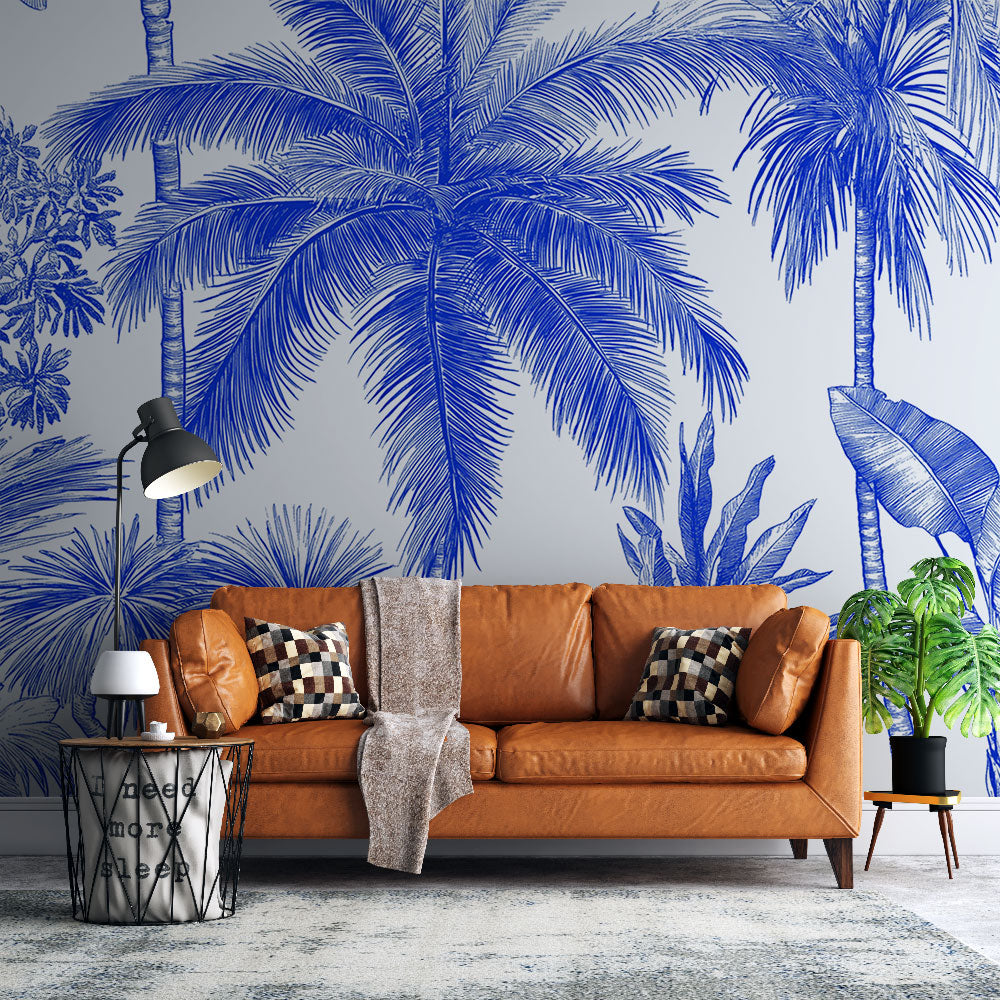 Blue palm trees tropical wallpaper mural styled in modern living room with white sofa and natural light