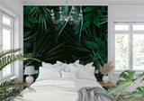 Dark green tropical leaf mural in a bedroom setting with natural light