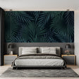 Tropical palm leaves wallpaper in modern living room with black sofa and natural light