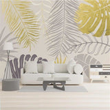 Tropical palm leaves wallpaper in gold and grey creating a luxurious atmosphere in a modern living room
