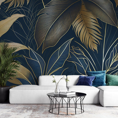 Tropical gold leaf wallpaper creating dramatic impact in a modern living room with navy blue and metallic accents