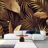 Tropical black and gold palm leaf wallpaper in modern dining room with dramatic lighting highlighting metallic details