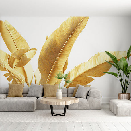 Golden banana leaf wallpaper mural creating a luxury tropical feel in a modern living room with white sofa and natural decor