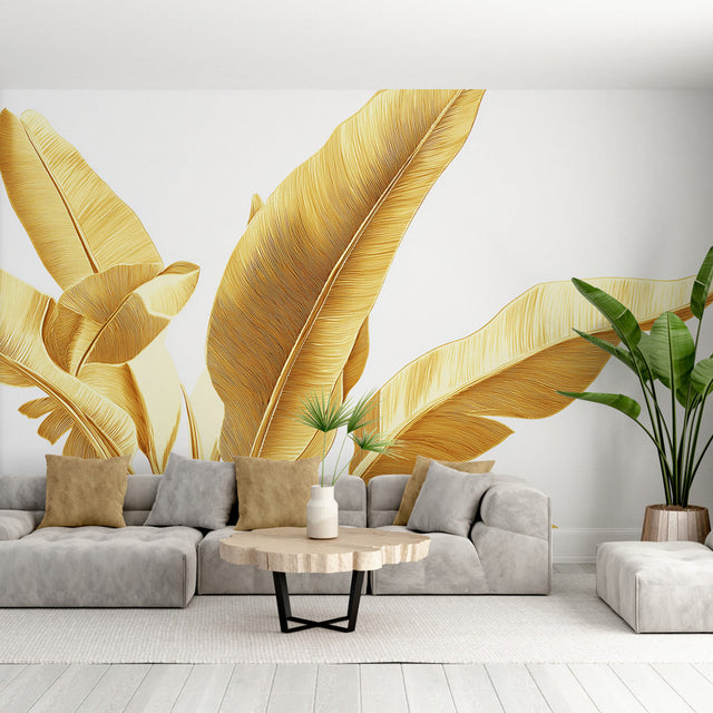 Golden banana leaf wallpaper mural creating a luxury tropical feel in a modern living room with white sofa and natural decor